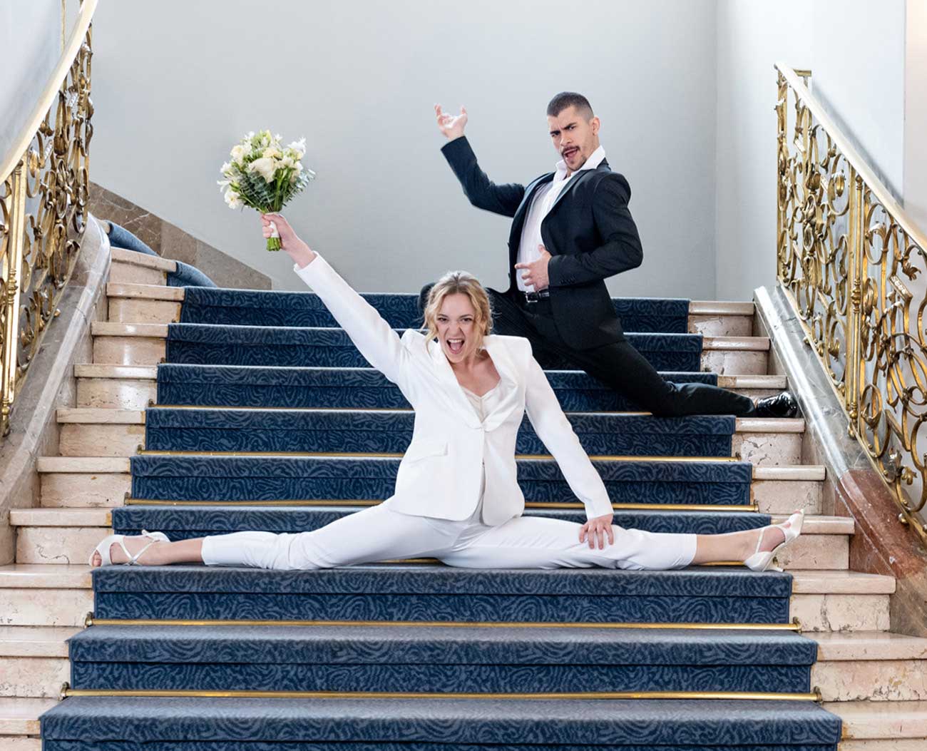 A bride does the splits on the stairs wearing Werner Kern shoes. 
