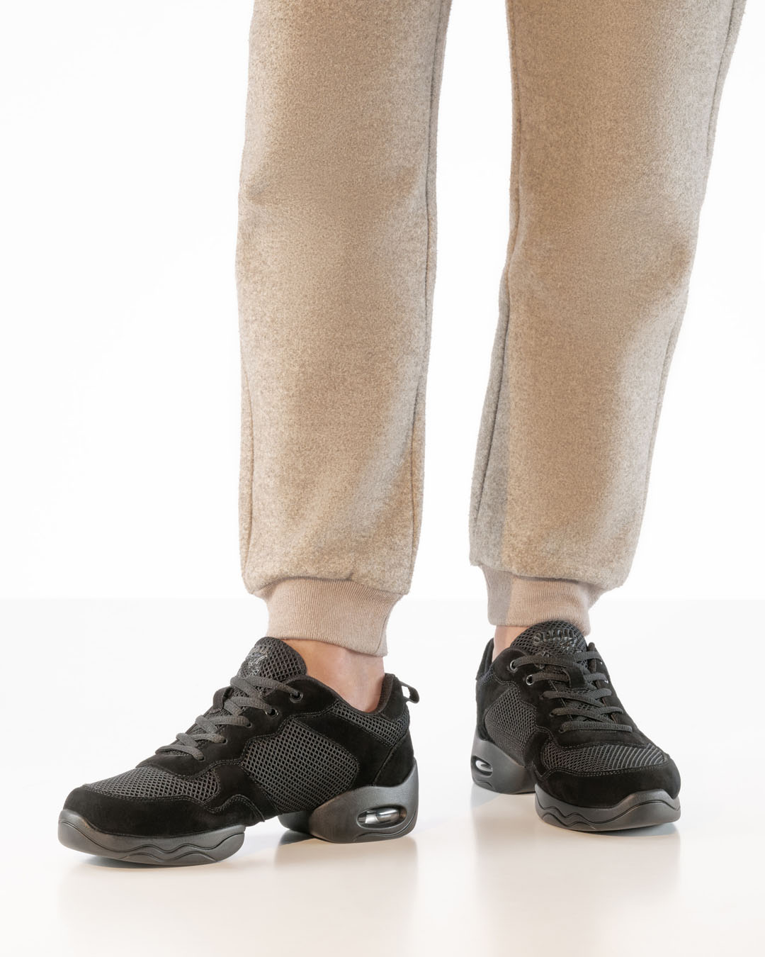 Black chunky-cut dance trainers with a split sole by Werner Kern, worn with beige trousers