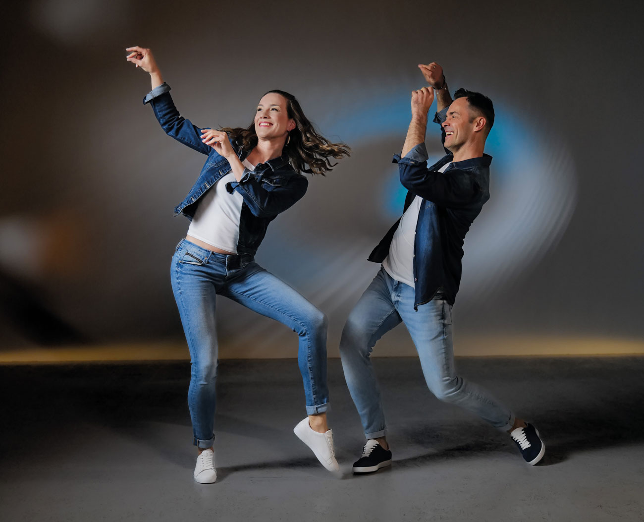 Dancing couple in jeans outfits and dance sneakers in blue and white leather