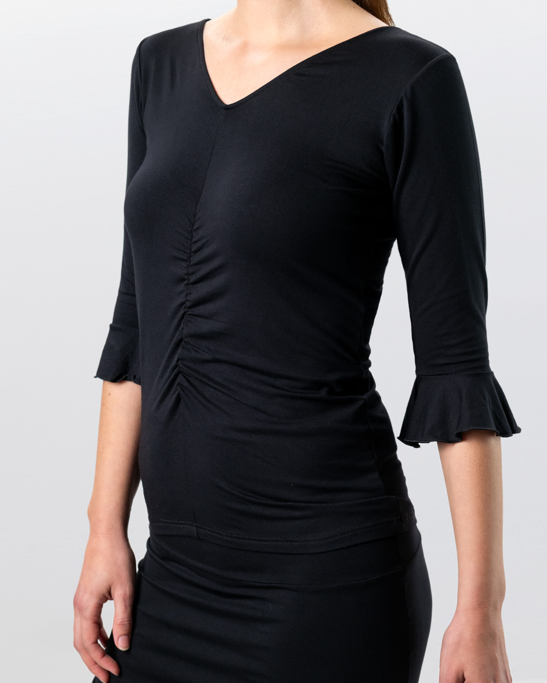 Dance top in black with 3/4 sleeves and V-neck at the front and back, made from soft, stretchy material