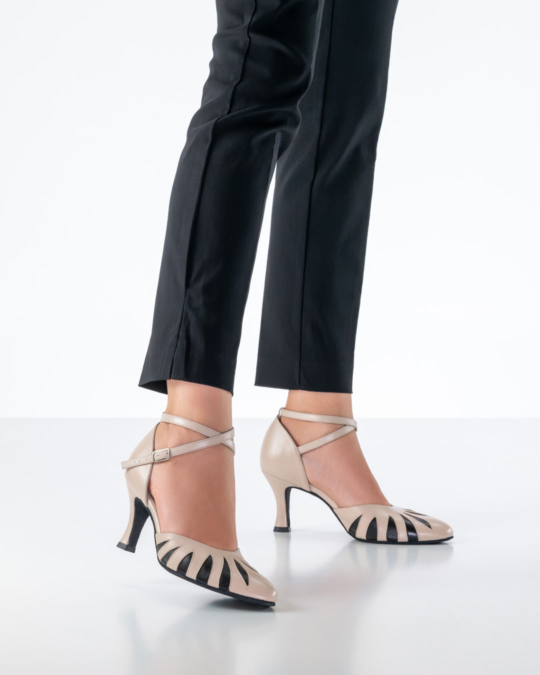 A model in tight black trousers is wearing beige, closed-toe ‘Donatella’ dance shoes by Werner Kern