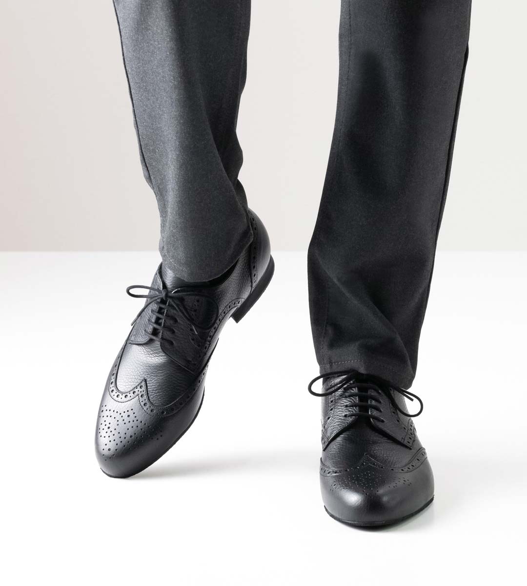 Bormio Men's dance shoe in black leather with 2 cm high heel in combination with grey trousers