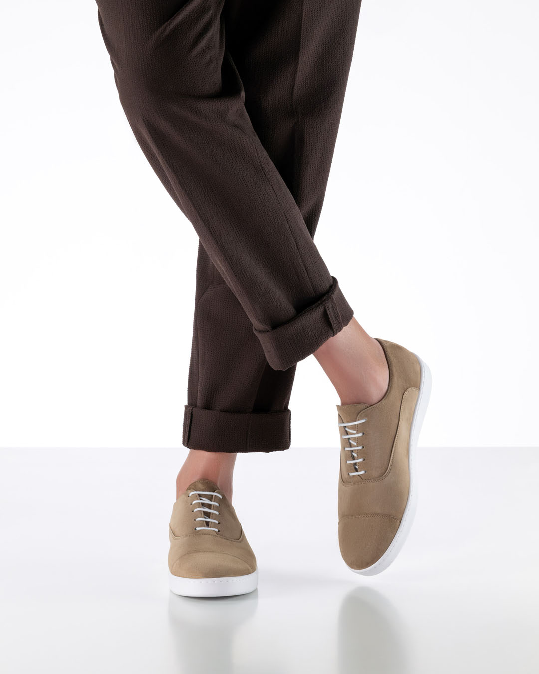 Men’s dancing shoes in beige leather with a white trainers’ sole by Werner Kern, worn with dark brown trousers
