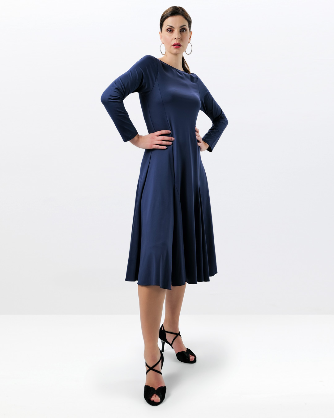 Model wears knee-length dance dress with wide, swinging skirt and long sleeves in blue