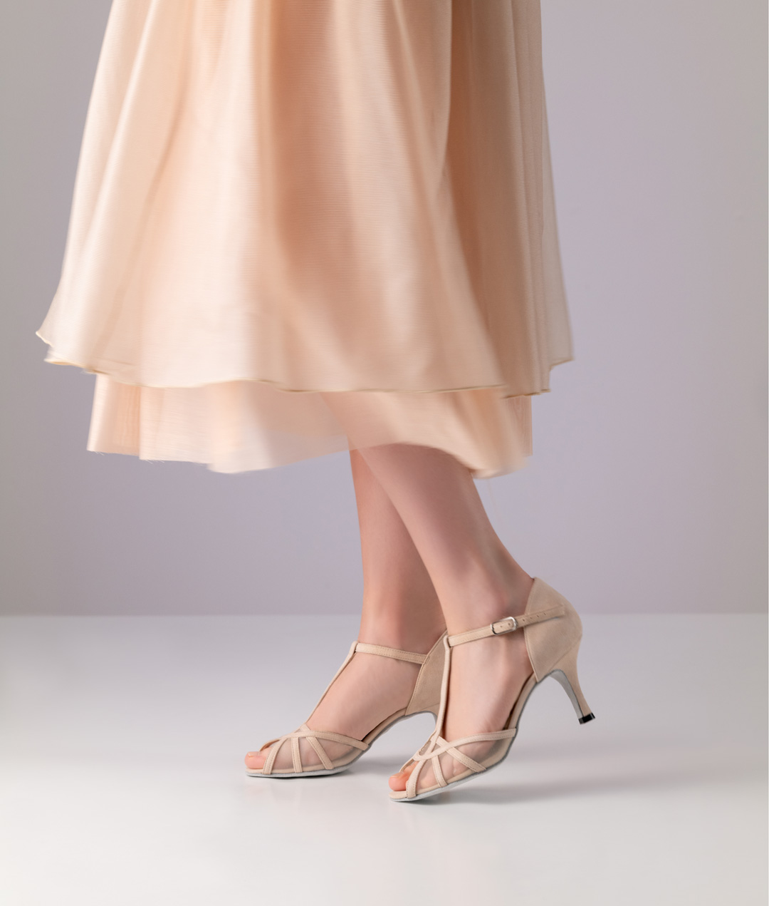 Nuria Open, elegant dance shoe made of shiny beige suede with a 7 cm heel from Nueva Epoca with a T-strap.