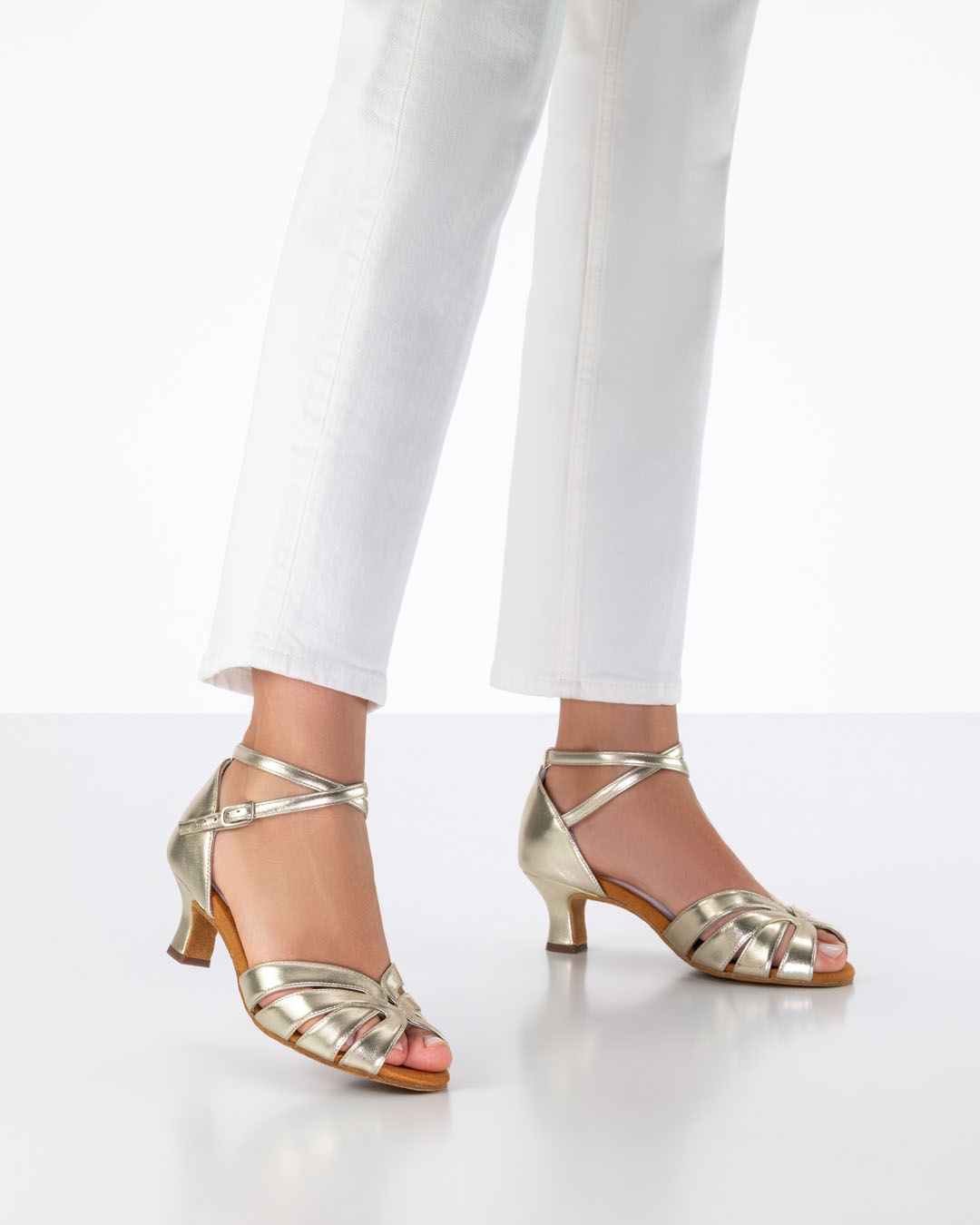 The model is wearing white jeans and gold dance sandals with a 5 cm flared heel