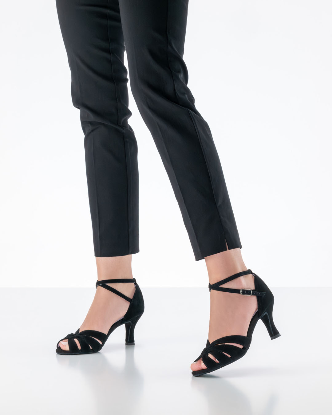 Black open-toed dance sandals ‘Olympe’ by Anna Kern, worn by a model in black trousers in the studio