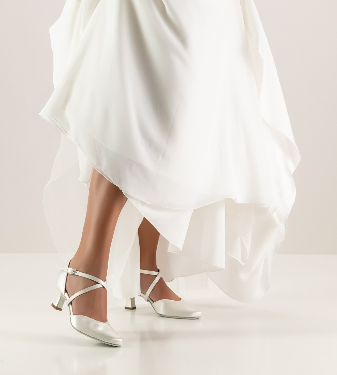 Wedding dress in white in combination with bridal shoe by Werner Kern