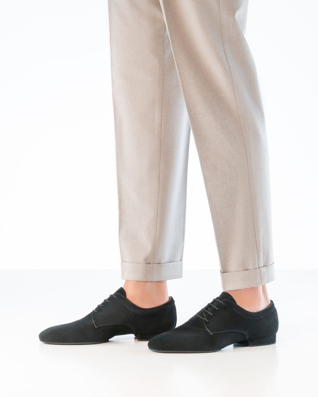 Vicenza men’s dancing shoes in black suede with a flat heel, worn with light-coloured trousers