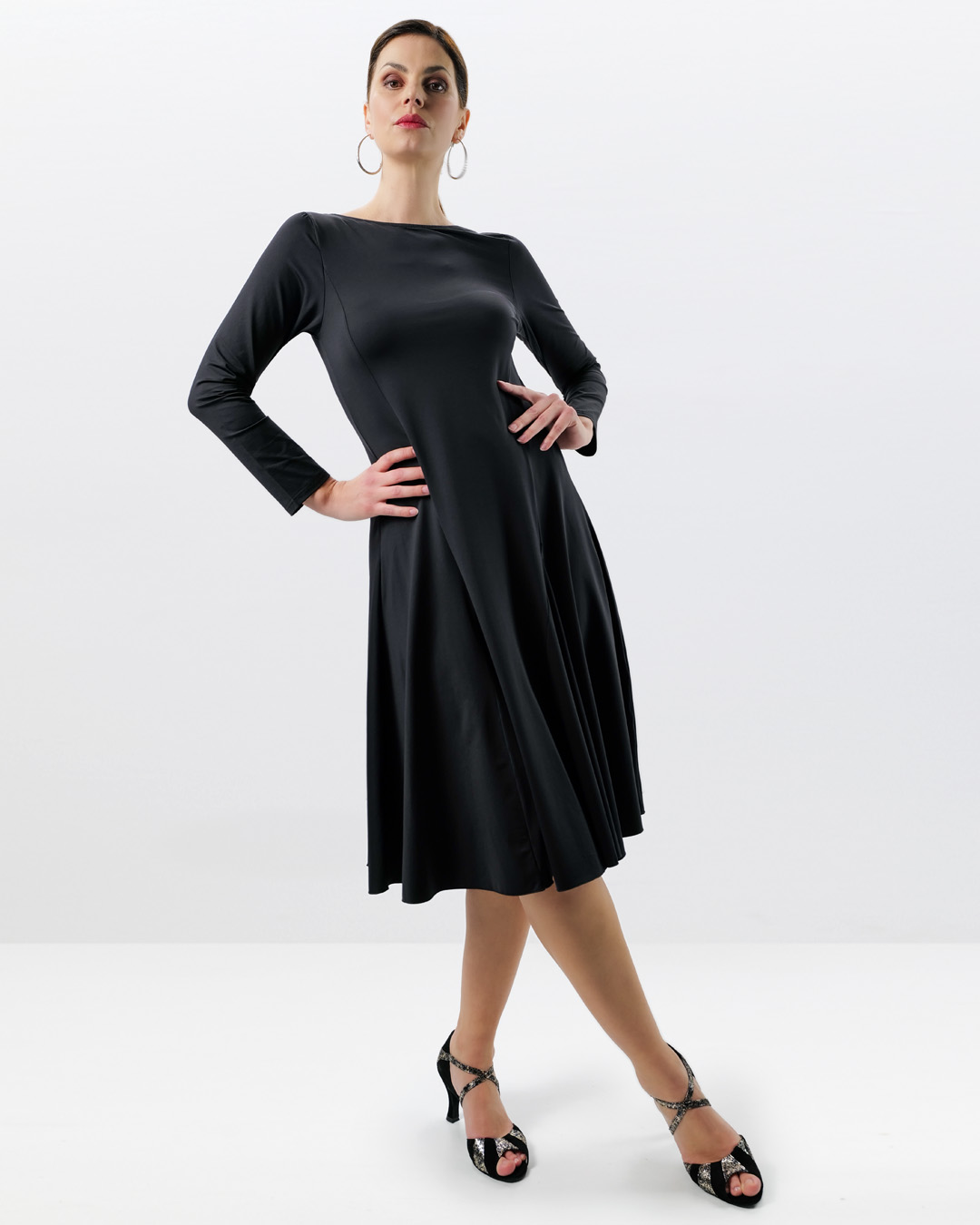 Model wears knee-length dance dress by Werner Kern in black with long sleeves and wide skirt