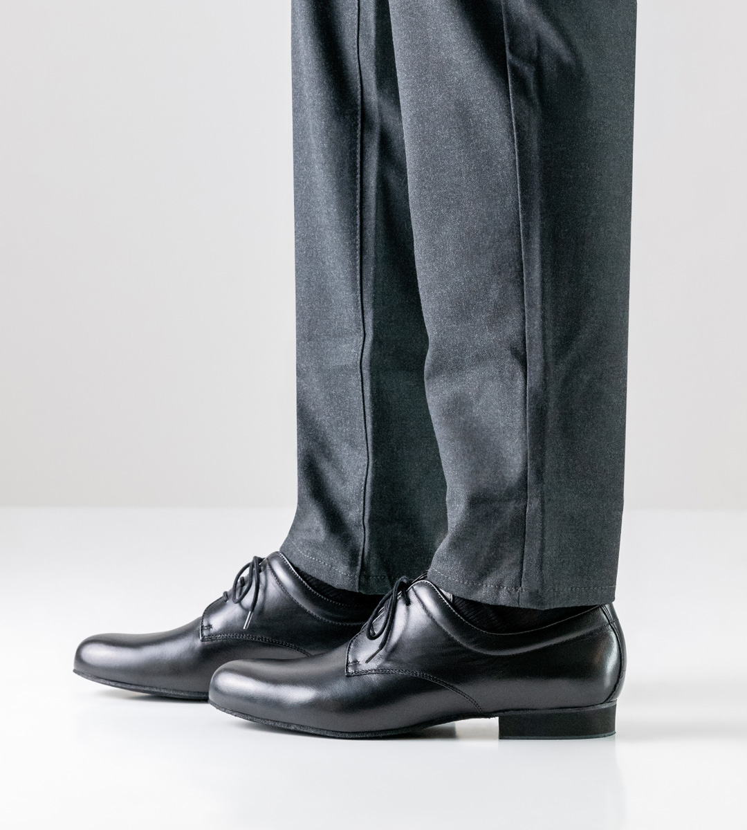 Side view of Werner Kern men's dance shoe with micro heel in combination with grey trousers