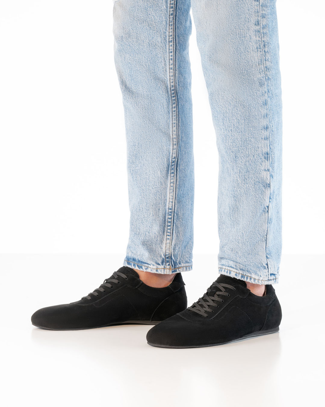 Black men’s dance shoes in a trainer style by Werner Kern, paired with light-coloured jeans