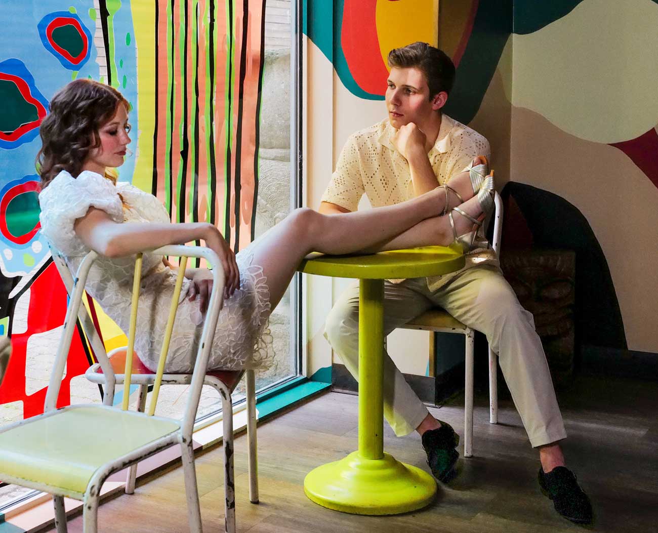 Bride and groom with dancing shoes take a break at table Bride and groom with dancing shoes take a break at table