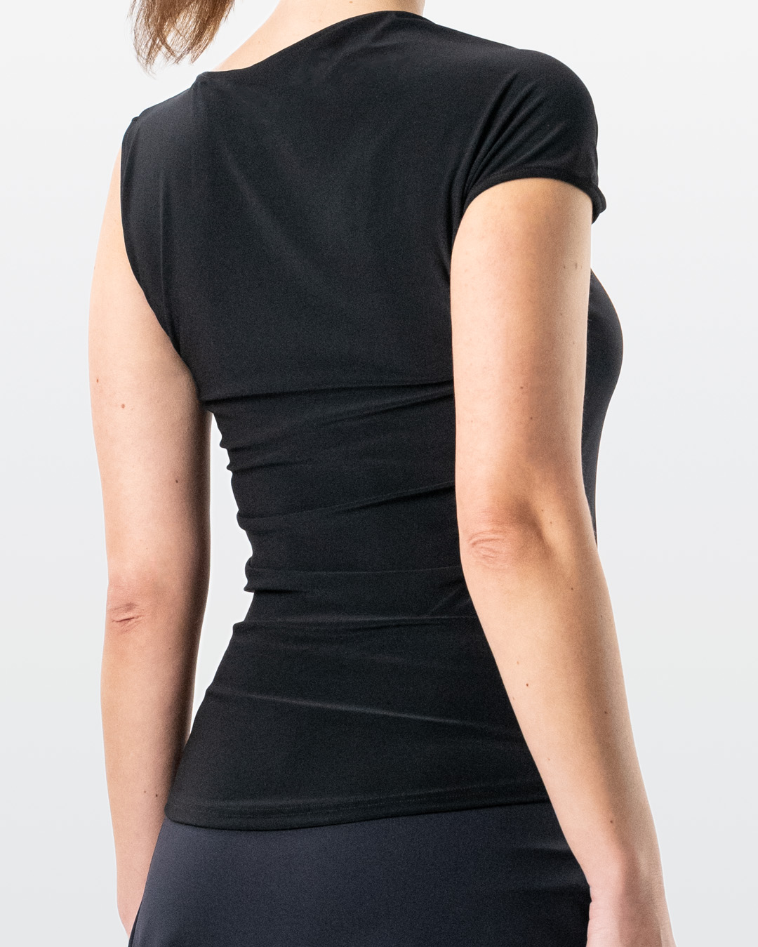 Rear view of Yari dance top in black with small sleeve on the right