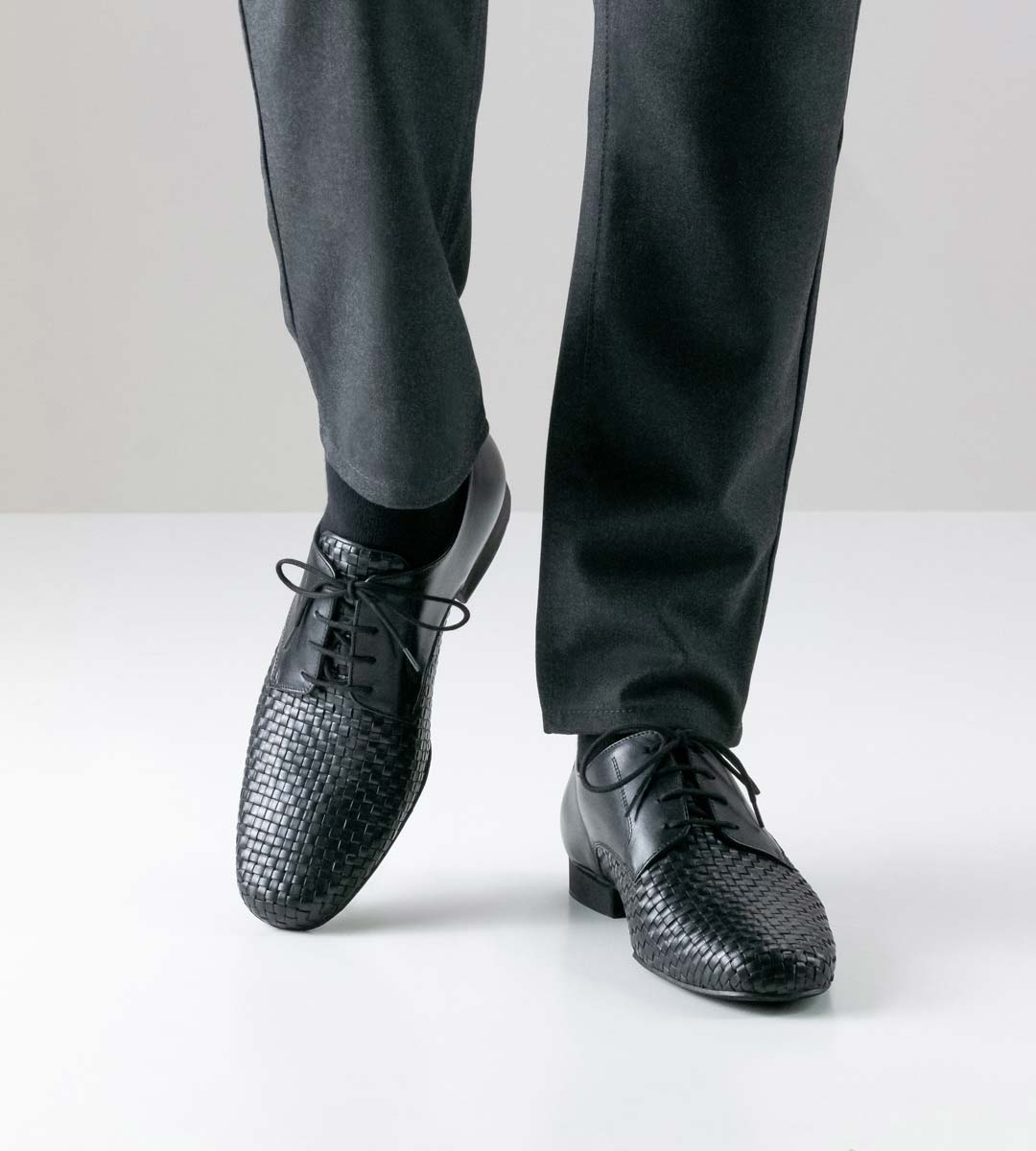 Como hand braided black men's dance shoe in combination with grey trousers