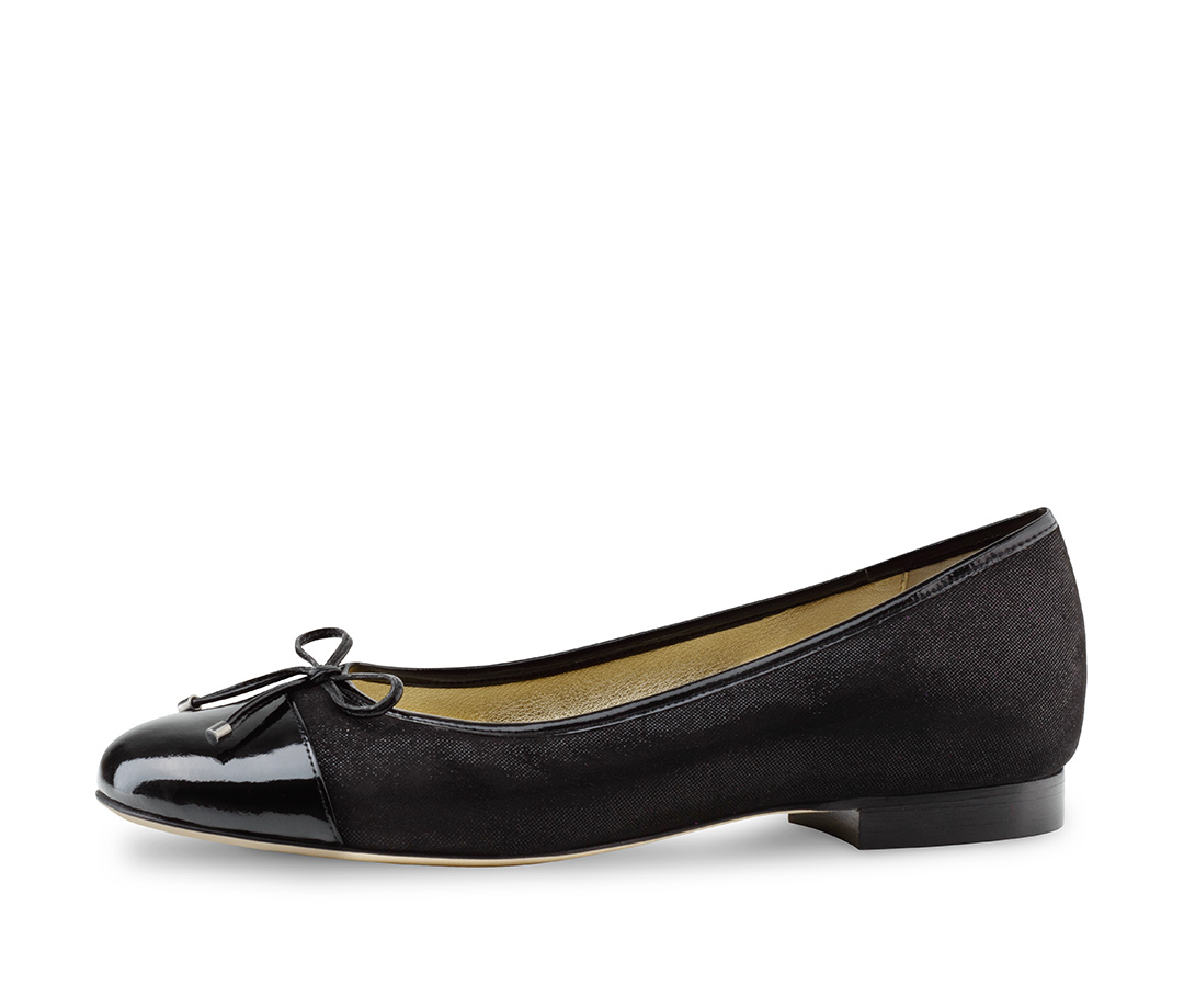 Jil A woman wears ballerinas in shiny black velour